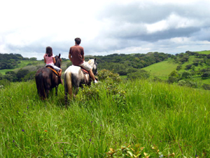 Two horseback riders enjoy the beautiful property and distant views.