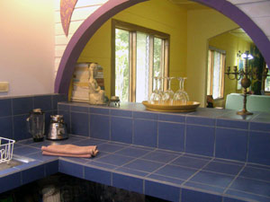 The kitchen in the main house is nicely remodeled with tile and an arched pass-through.