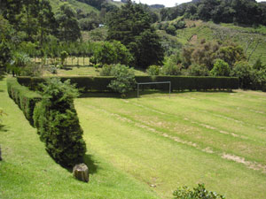 While high in the rugged maountains, the beautiful ranch has a big soccer field bordered by sculpted hedges. 