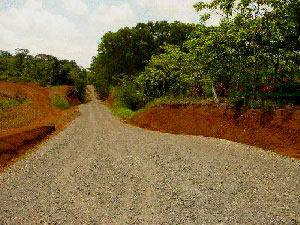 A wide, thickly graveled road leads into the de3velopment.