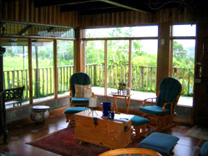 The living room in the main house is a bright and comfortable area with fine woodwork and enveloping windows.