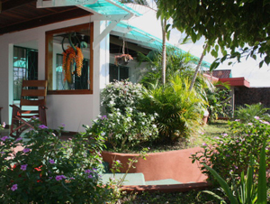 The outdoor dining area is partially screened by the attractive front garden.