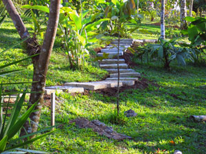 A path leads through landscaped grounds toward the woods.