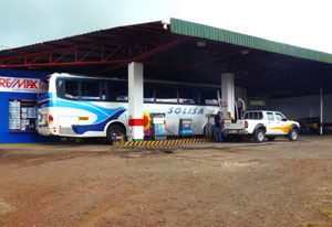 A tour bus gasses up at the Lago Arenal station while riders visit the mini-store and the restrooms. 