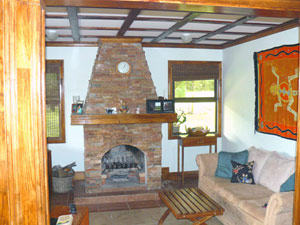 The den contains a large stone wood-burning fireplace. 