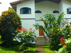 There is beautiful mature landscaping with exotic plants around the parking space and the short walkway to the entrance.