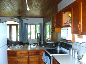 The kitchen has a view past the breakfast bar and living room to the lake.