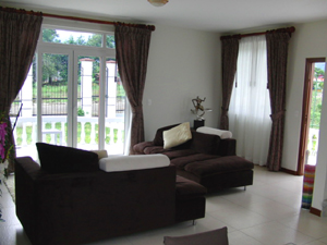 The living room has an outdoor feel because of the oversize windows and doors.