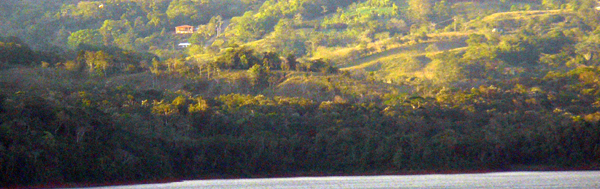 The 11-acre property is located in a forested area near the village of Aguacate. It is seen here along with the caretaker home in the view from across Lake Arenal.