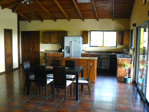 The kitchen and dining area as well as the living room are in an open configuration with a wooden cathedral ceiling.