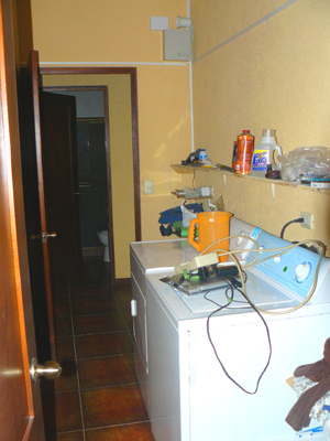 A very large high-ceiled laundry room is behind the kitchen.