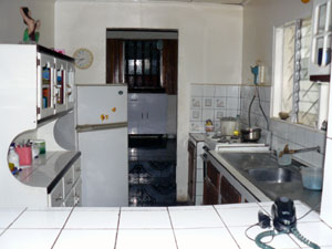 The kitchen has a pass-through to the dining area and two steps up to the L section of the house.