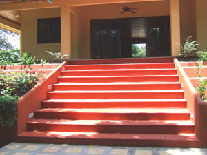 The home has wide set of entrance steps leading from the creekside deck to the house.