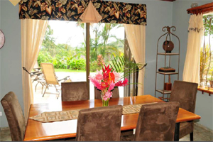 The dining room has large windows and access to the broad patio and pool.