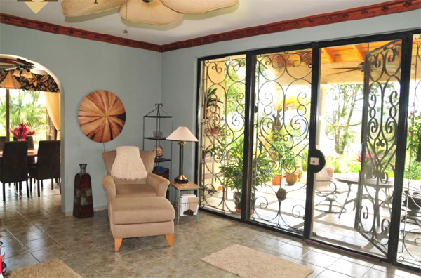 The large living room has a full wall of glass doors opening to the broad covered patio.