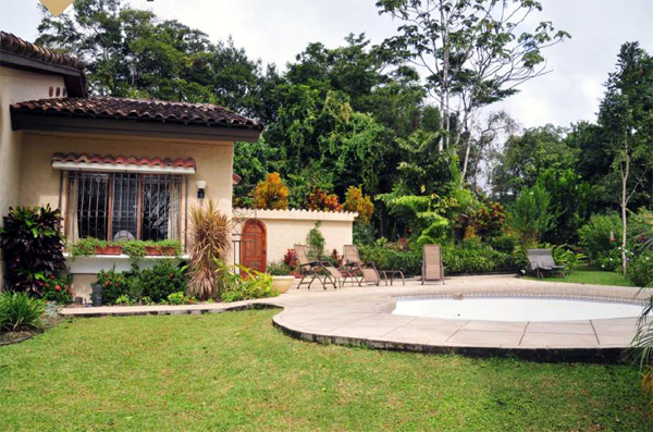 The in-ground pool with large pool house in colonial style.