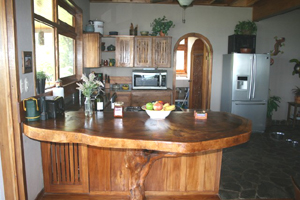 The heavy hardwood of the breakfast bar exemplies the partial well integrated rusticity of the house.