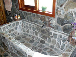 The master bathroom has a stone bathtub as well as the shower.