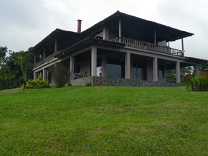 The house has a wide veranda on two sides of the first floor and separate balconies on the second floor for the master suite and family room.