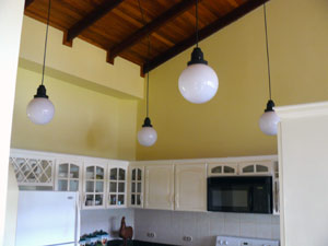 This view of the kitchen shows the unique lighting and the high ceiling.