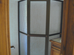 The master suite bathroom has a semi-circular frosted glass shower. 