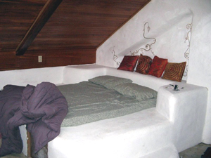 The main sleeping area is a large straw-bale platform with built-in drawers.