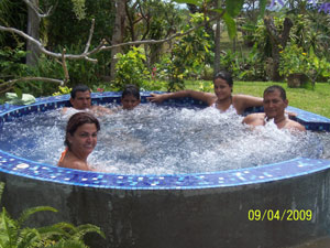 The family sits neck deep in the bubbling, colorfully tiled spa.