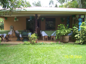 The house is set among shade trees and oramentals with a wide level lawn in front of the veranda.