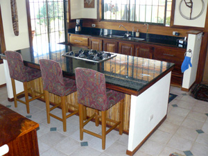 The bright unique kitchen has fine custom hardwoods and granite countertops, including the very large island with a gas cooktop. 