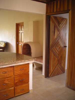 The remodel work includes fine kitchen cabinetry as well as the wood-burning firelace seen beyond in the family room.