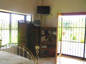 The large master bedroom has sliding glass doors to the patio and a very large bay window.