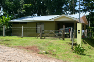 The home is next to a forested valley with a stream.