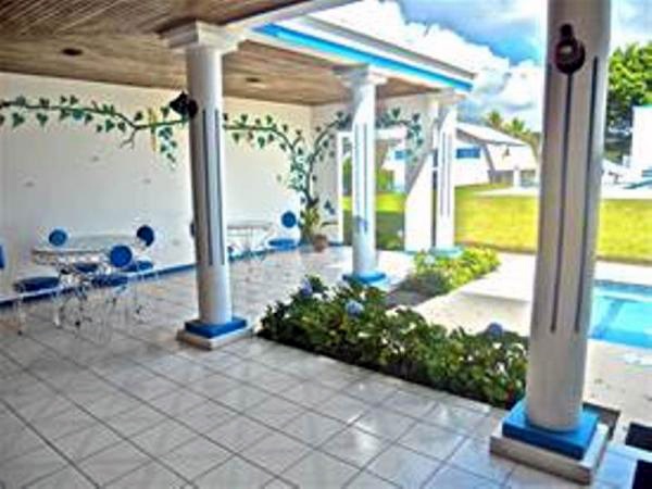 Partly surrounding the pool and jacuzzi area is wide colonaded patio.