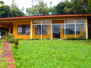 A path leads from the serice station parking area uphill to the glassed in patio at the front of the house.