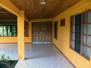 The patios and tiled carport wrapping the front and west side of the house lead to a handsome sliding double door, which enables easy entry of large items to the house.