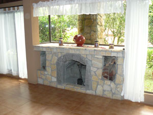 The living room has a pretty white-stone fireplace.