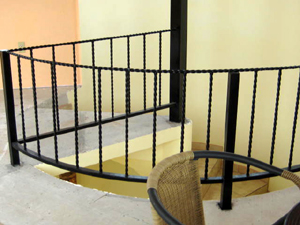 Wrought-iron railing guards the central stairway on the third floor. 