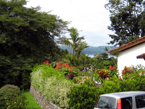 The house has a paved driveway, a connected one-car garage, and mature ornmental landscaping in additional to its lake views.