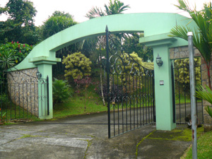 The formidable entrance gate is at the top of a paved road that serves the 6-property decade-old well planned development.