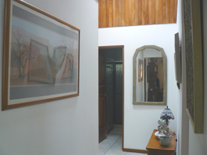 A hallway leads to the second bedroom and third bathroom in the home.