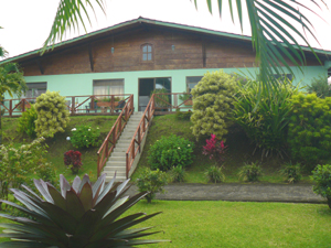 The single-story house has a wide footprint on its forest-backed site overlooking Lake Arenal.