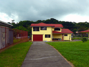 From the automatic back gate, a wide driveway leads either to the garage or to the driveway curving around the house to the front entrance and parking area.