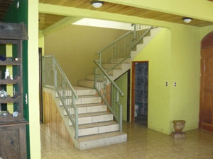 A wide staircase leads to the second floor. A powder room is located beneath the staircase.