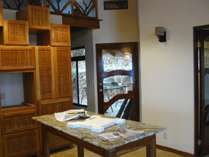 The handsome custom door of glass and artistically shaped hardwood leads to the back patio.