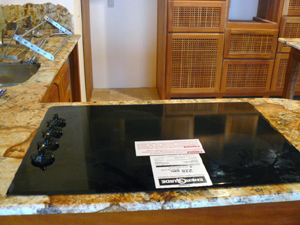 An  electric cooktop has been installed in one of the ktichen's granite counters. Other appliances are of top quality also.