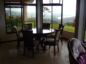 the dining area is in a floor to ceiling bay with lake and volcano views.