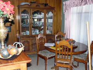 The handsoely furnished dining room is served by a passthrough and doorway from the kitchen. The pass-through is also a breakfast bar.