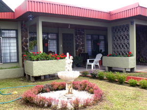 The home has a ery nice appearane in front with a small gardon, potted plants, statuary, and decorative ironwork.