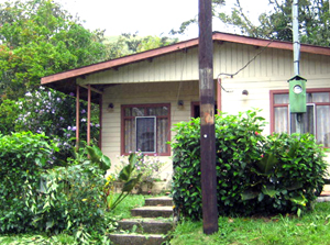 The 2BR 1BA house, partially screned by trees, is right beside the lake road, but has a lot of 2+ acres rising steeply up behind it.