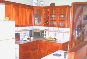 The kitchen is a neat space with fine wood cabinetry.